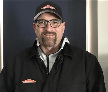 smiling bearded man with a black and green Servpro shirt on