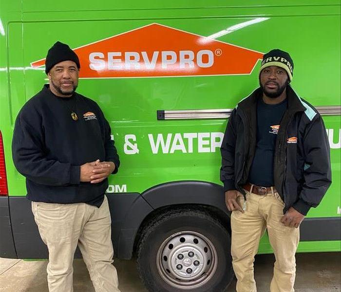 2 servpro technicians in front of a servpro truck